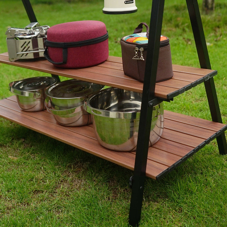 Outdoor furniture with wooden shelves and metal bowls on a grassy background